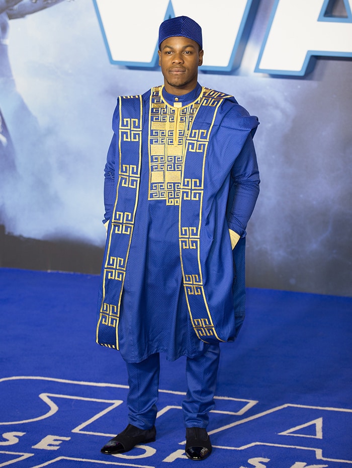 John Boyega wears a traditional Nigerian Agbada dress with Fila hat and black shoes