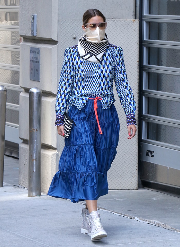 Olivia Palermo continues her style streak in a patterned, blue long-sleeved blouse and a pleated, ruffled midi skirt