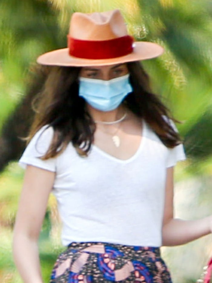 Ana de Armas styles her look with a Panama hat with a red velvet ribbon