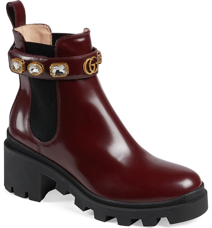 Bejeweled straps encircle the elastic-inset shaft of a sleek leather Chelsea boot set atop a chunky lug sole