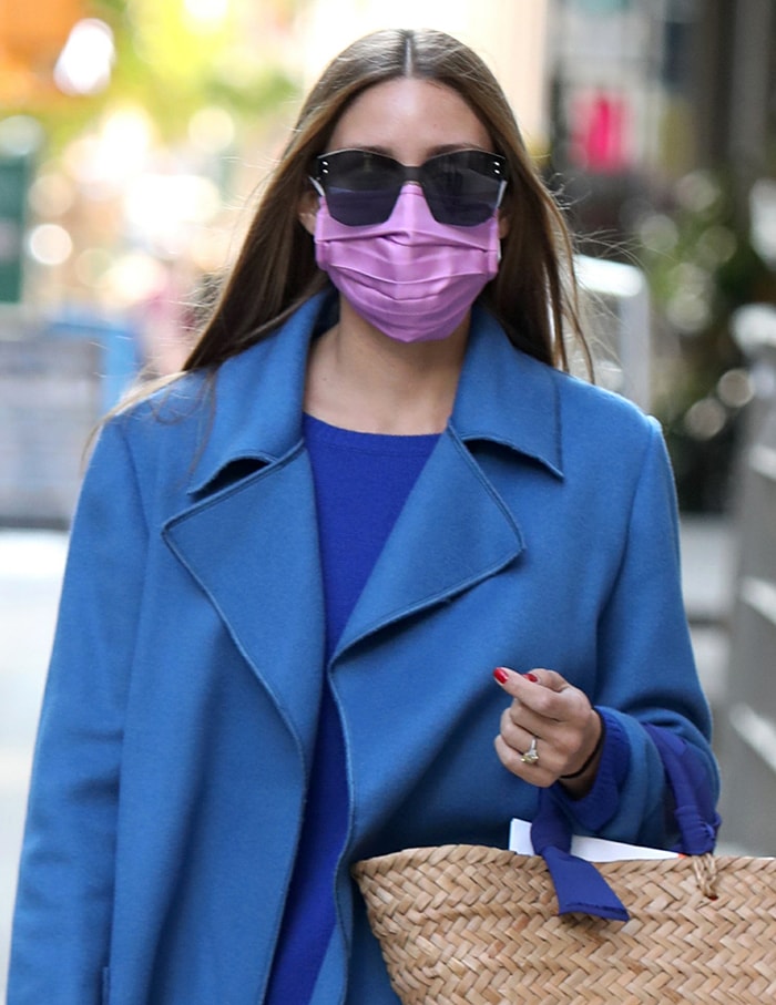 Olivia Palermo styles her glossy tresses straight and wears a lavender face mask with oversized sunglasses