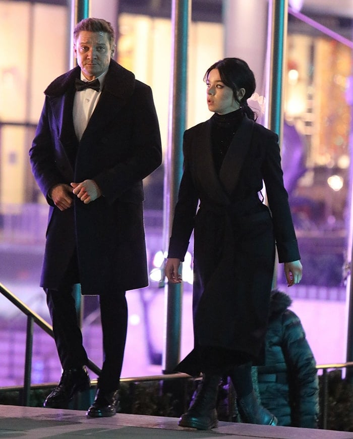 Jeremy Renner in a tuxedo and Hailee Steinfeld in a trench coat on the Hawkeye set