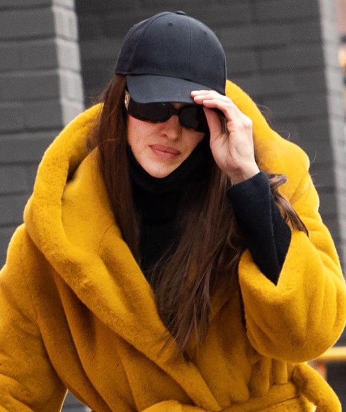 Irina Shayk keeps the rest of her look low-key with a black cap and Linda Farrow sunglasses