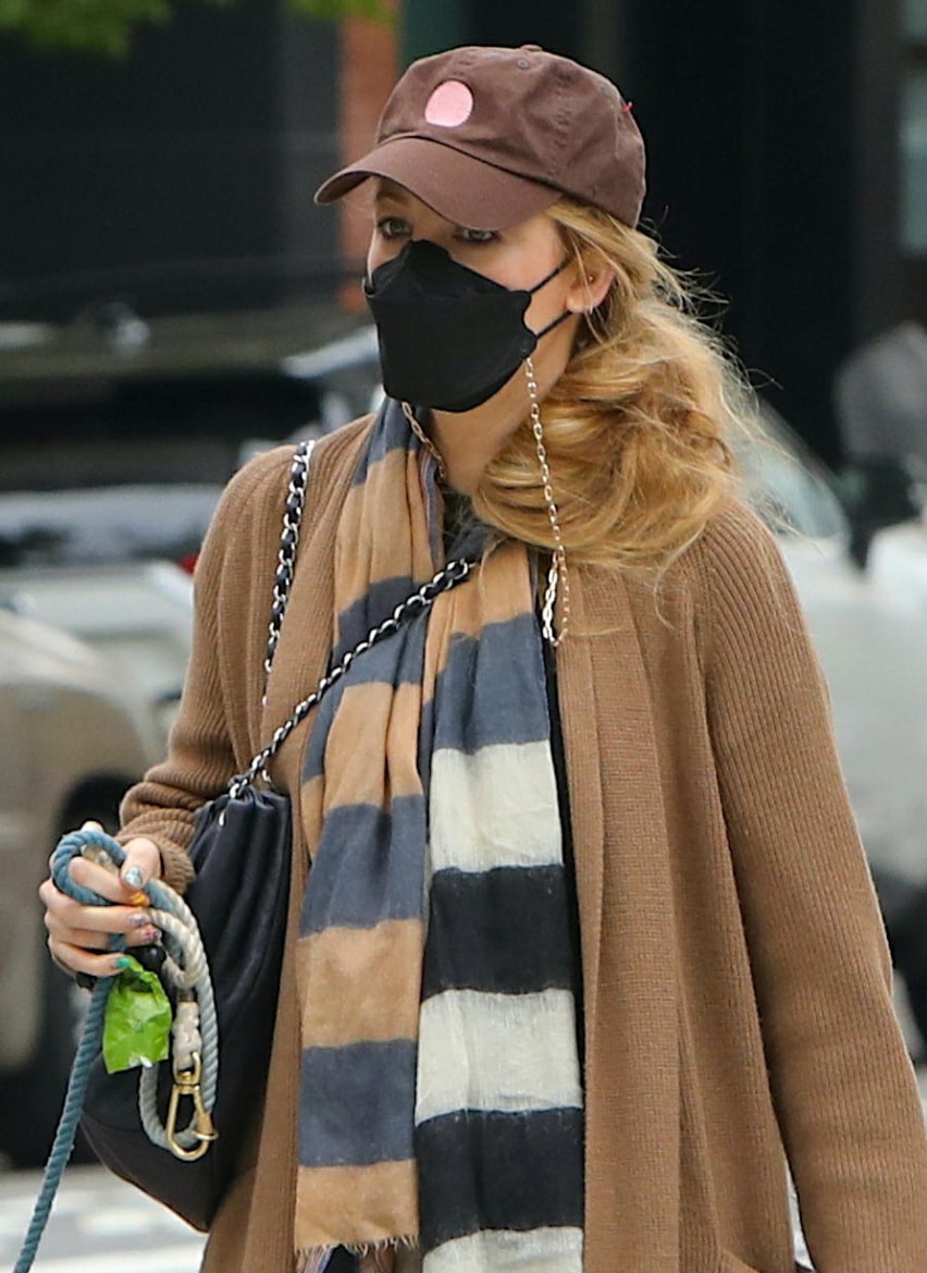 Blake Lively wears a wavy ponytail and keeps a low profile with a brown cap and a black face mask