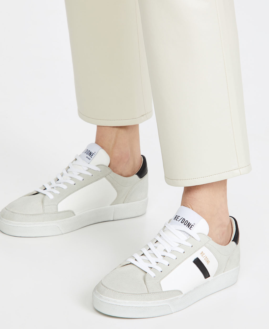 A pair of sustainable sneakers featuring a subtle mix of faux leather and faux suede materials