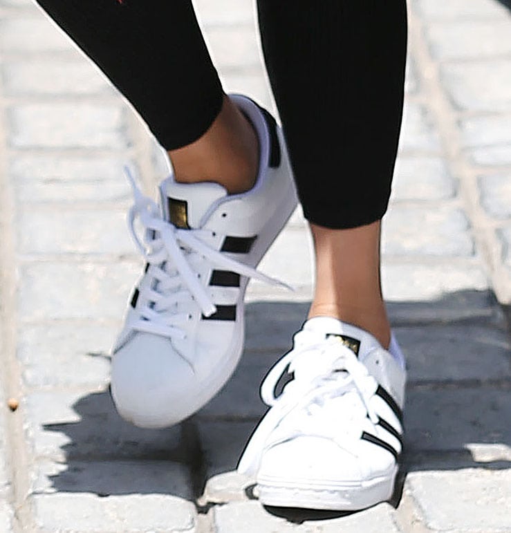 Chrissy Teigen pairs her effortlessly cool outfit with the classic Adidas Superstar sneakers