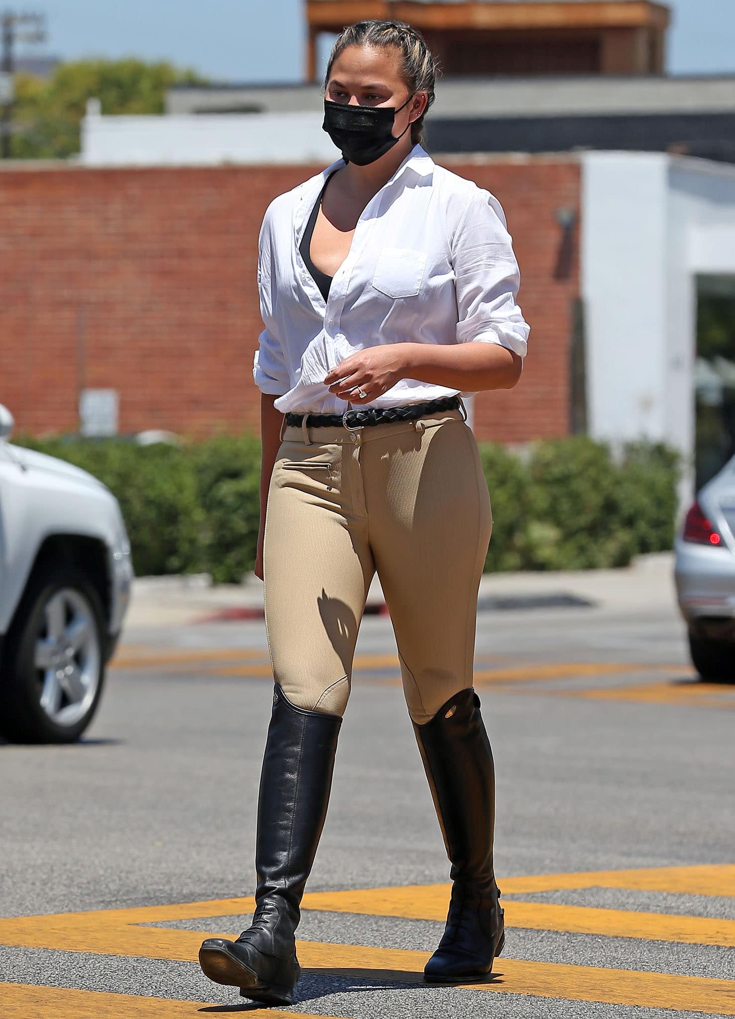 Chrissy Teigen opts for an equestrian-inspired outfit with Frank & Eileen white shirt, Tuffrider pants, and Isabel Marant belt