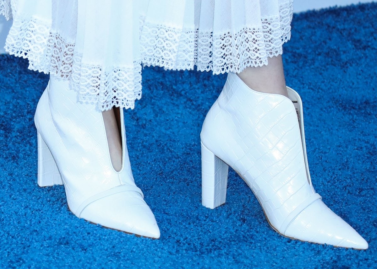 Hunter Schafer wears white Malone Souliers boots with a matching Loewe dress