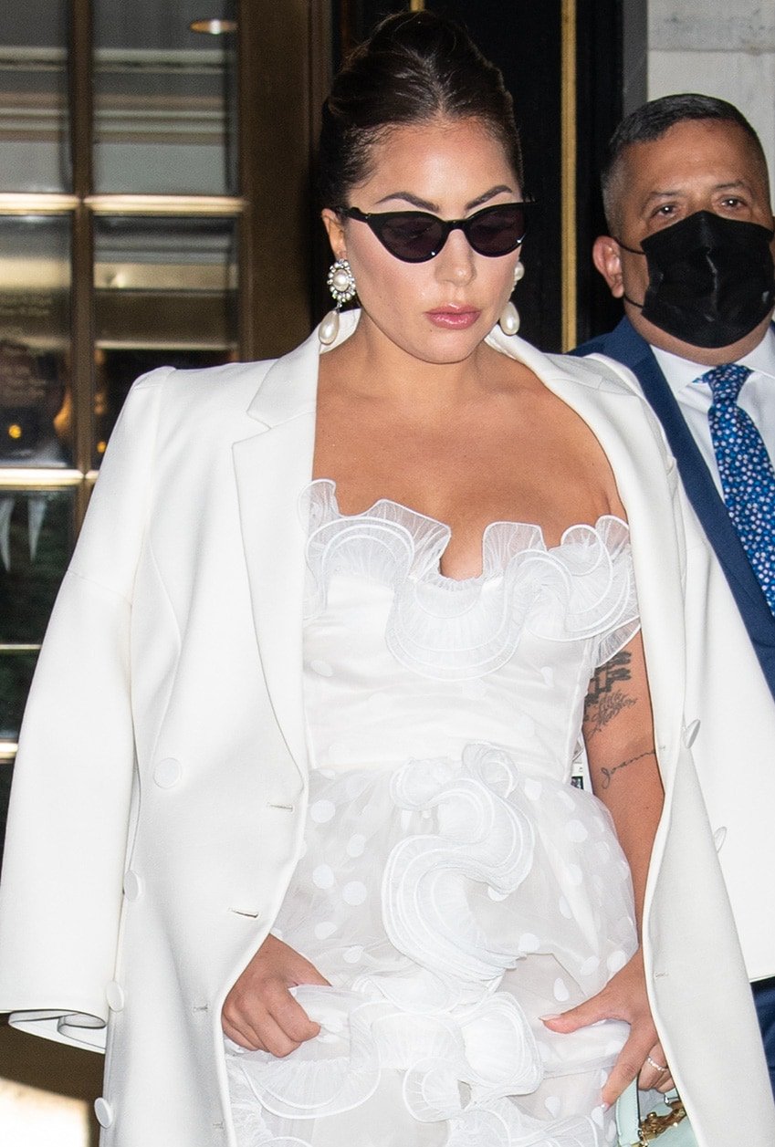 Lady Gaga accessorizes with Alessandra Rich earrings and wears a center-parted French twist with pink lip gloss