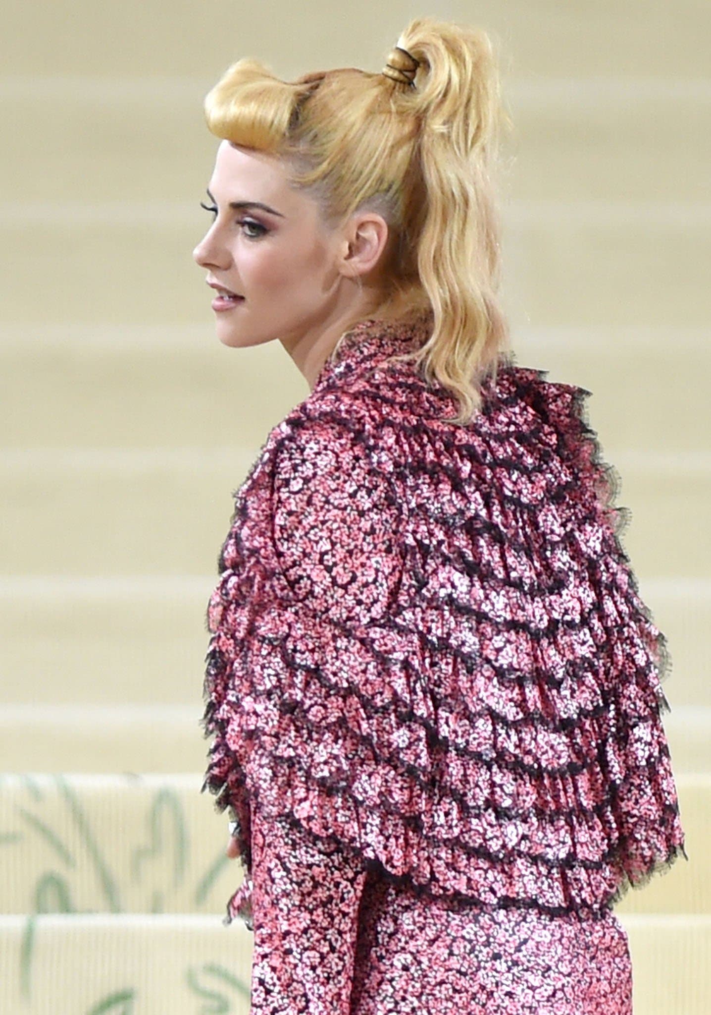 Kristen Stewart wears barbie pink smokey eye-makeup and styles her hair in a high ponytail with faux-fringe