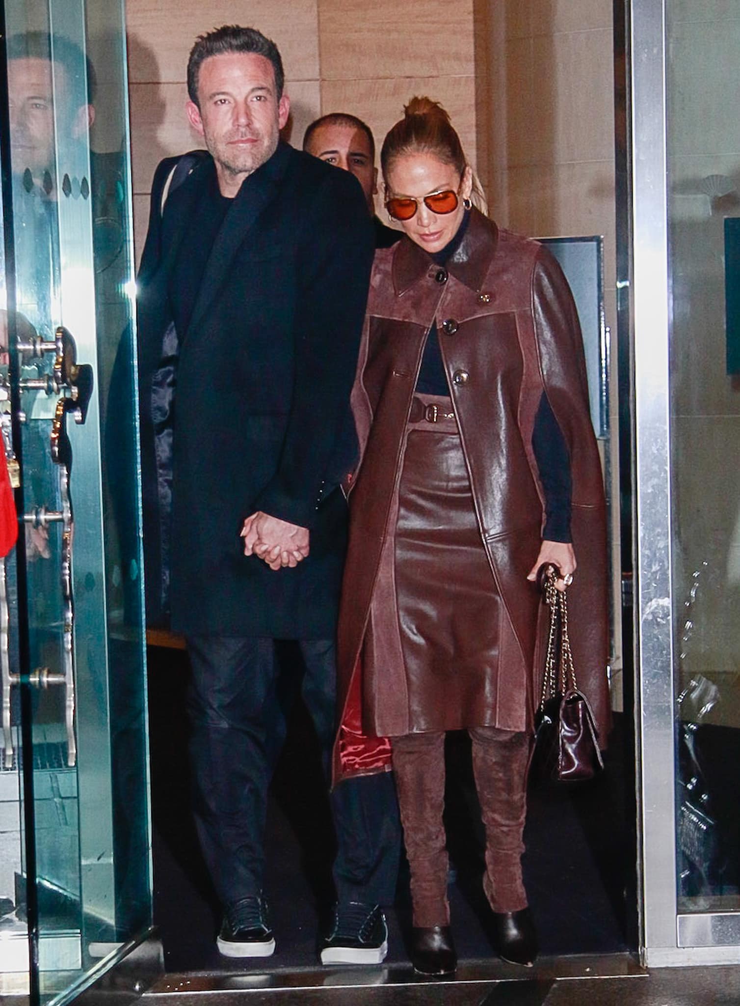 Jennifer Lopez in Gucci brown leather and suede cape coat, midi skirt, and Balmain over-the-knee boots