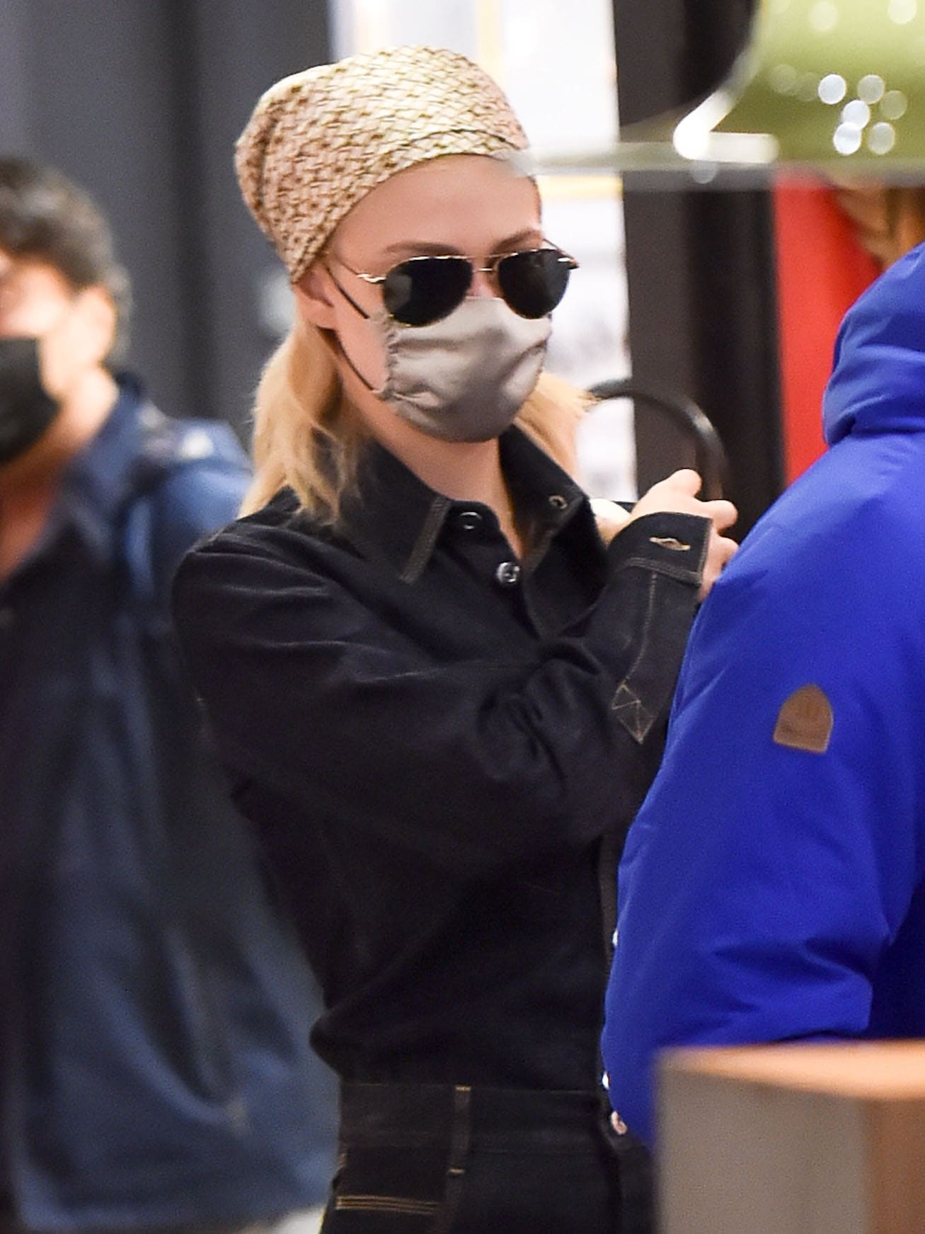 Nicola Peltz styles her tresses down underneath a gold and beige silk satin bandana