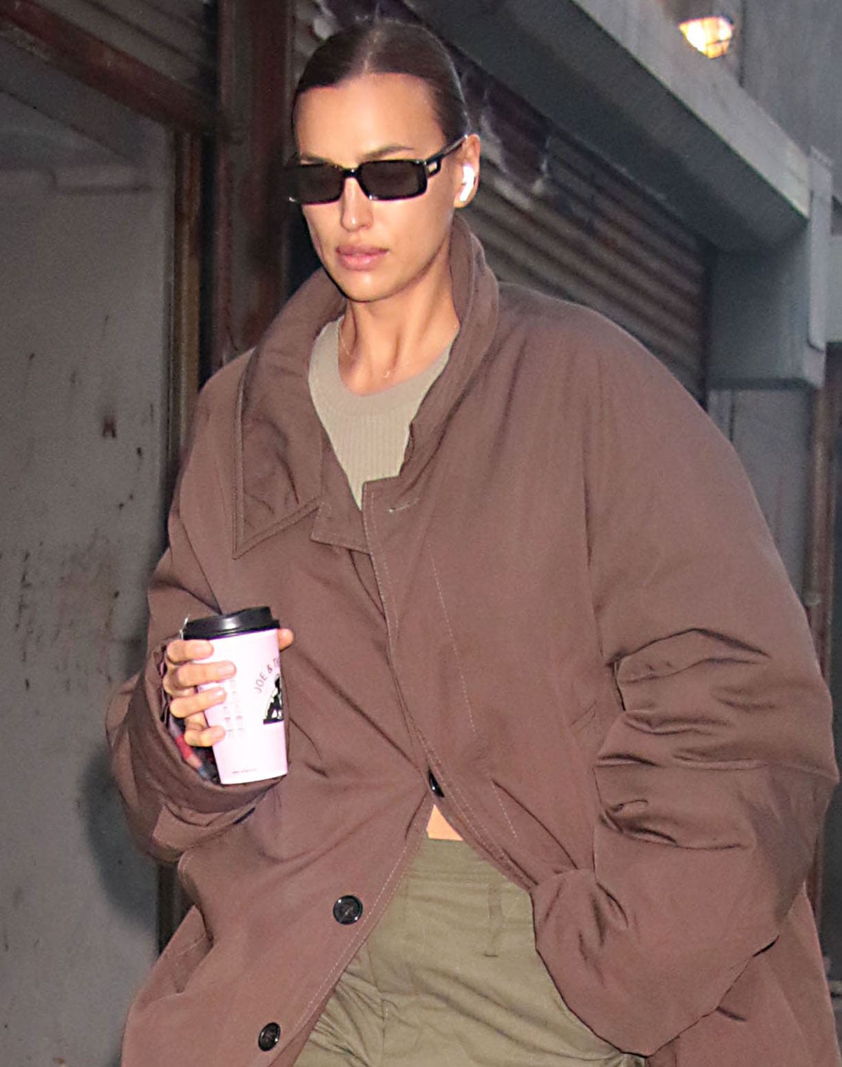 Irina Shayk wears a sleek ponytail and hides her eyes behind a set of rectangular black sunglasses