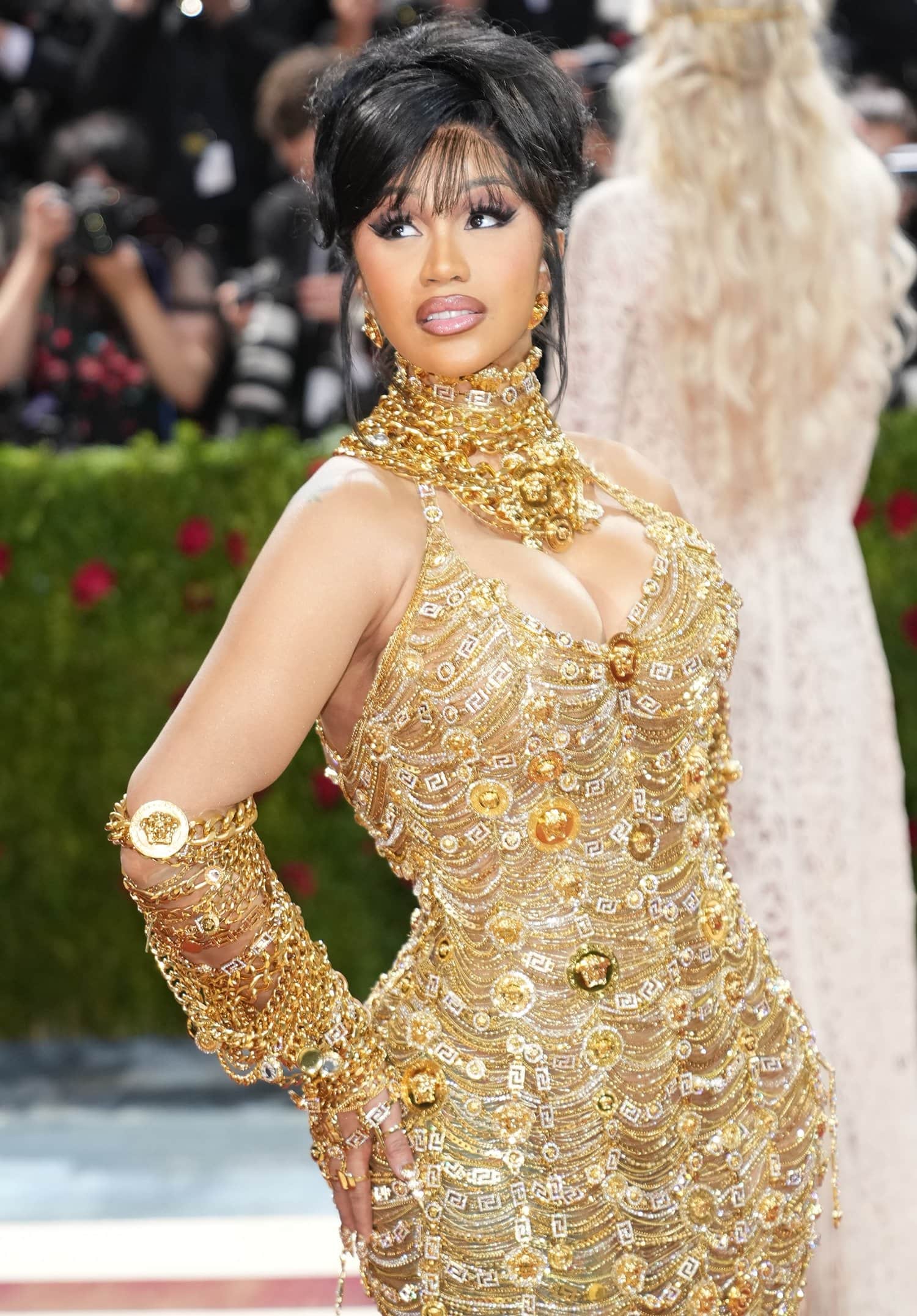 Cardi B stunned in a custom gold jewelry-covered gown by Versace featuring gold bracelets and necklaces