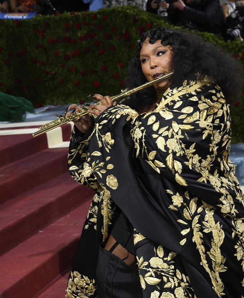 Lizzo Plays Gold John Lunn Flute on Met Red Carpet