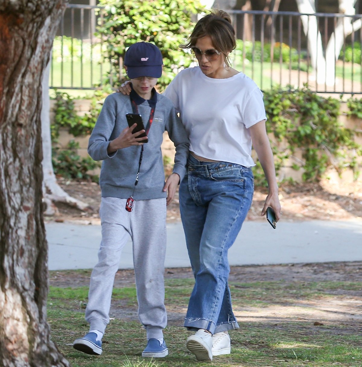 Jennifer Lopez keeps it effortlessly chic in a cropped white tee, crossover jeans, and white sneakers while strolling with her son Max in Los Angeles