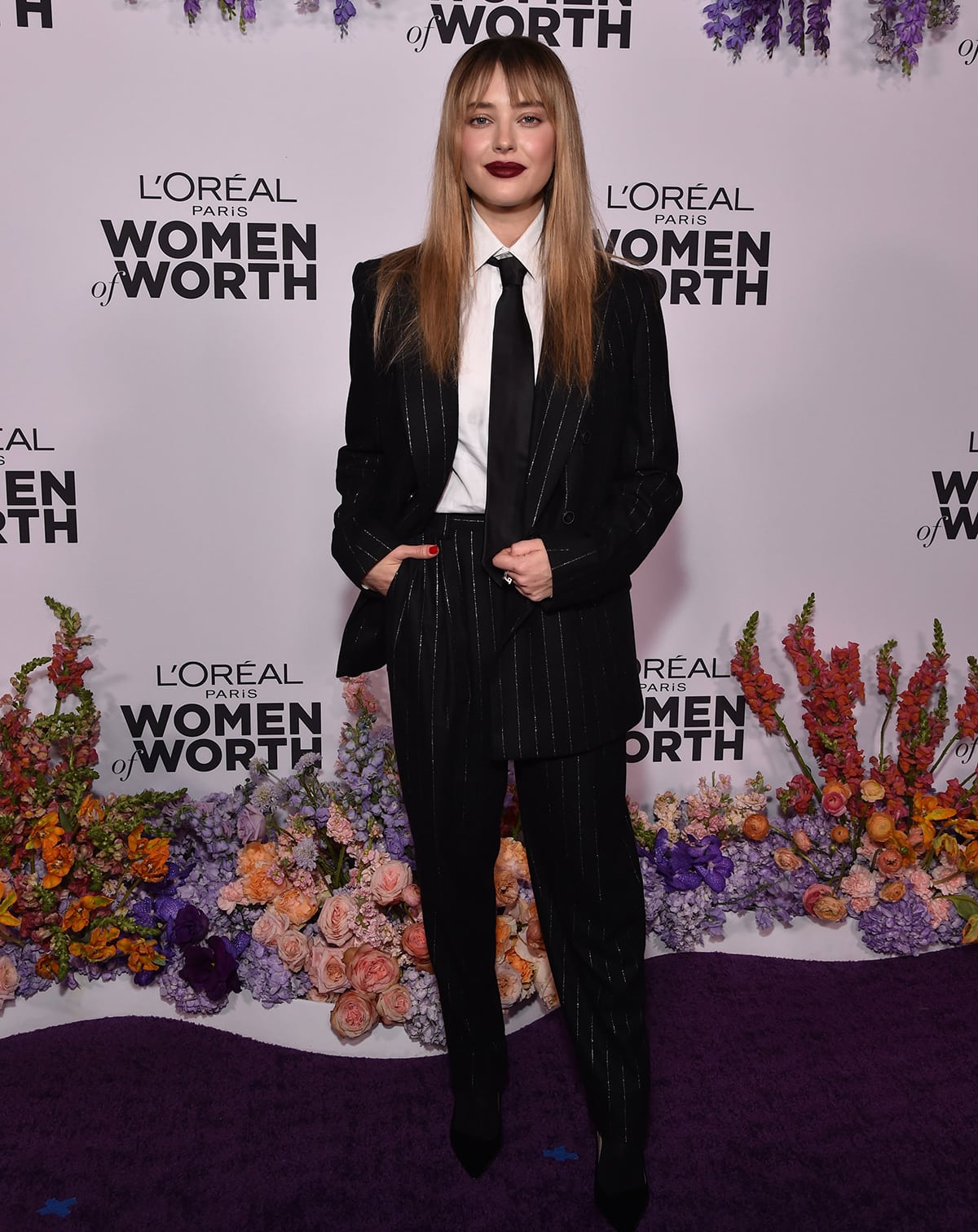 Katherine Langford takes inspiration from Julia Roberts in a menswear pinstripe suit with a white shirt and a black tie by Armani