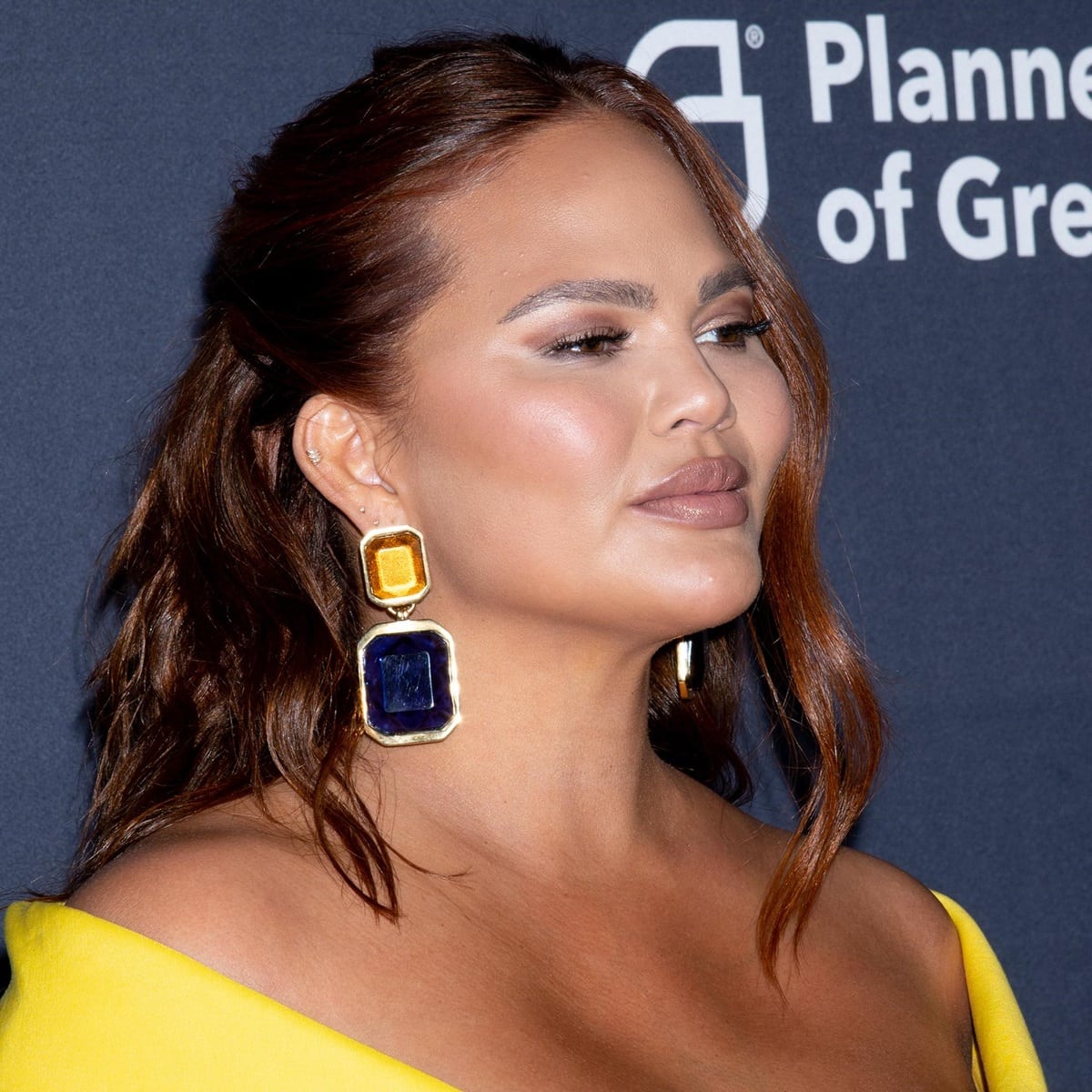 Chrissy Teigen's clip-on earrings from Saint Laurent feature a resin-replica faceted stone design that adds texture and depth to any outfit while keeping the earrings lightweight