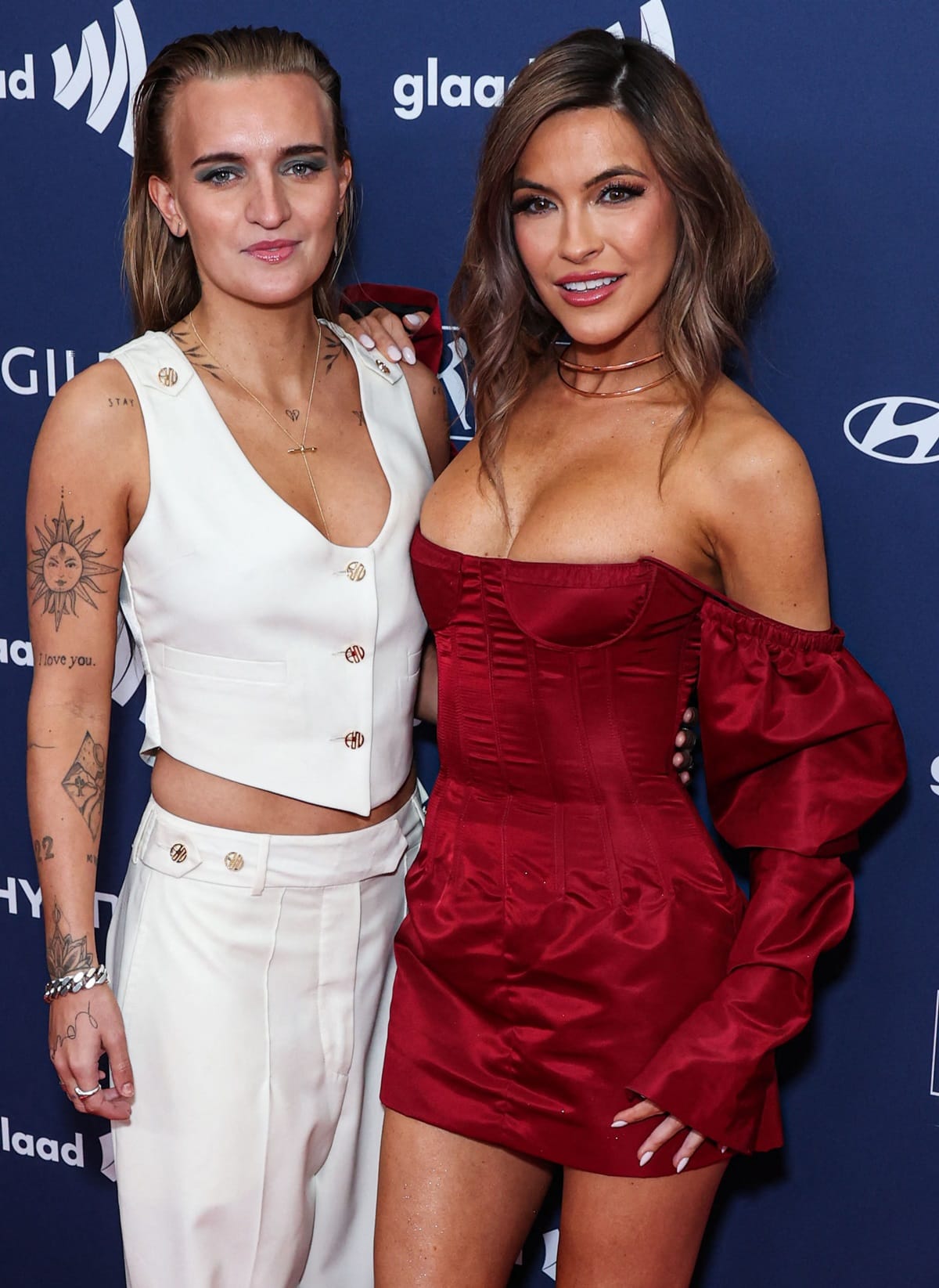 Chrishell Stause wore a tight red dress with an off-the-shoulder sleeve while G Flip donned an off-white ensemble consisting of a sleeveless button-up crop top and trousers