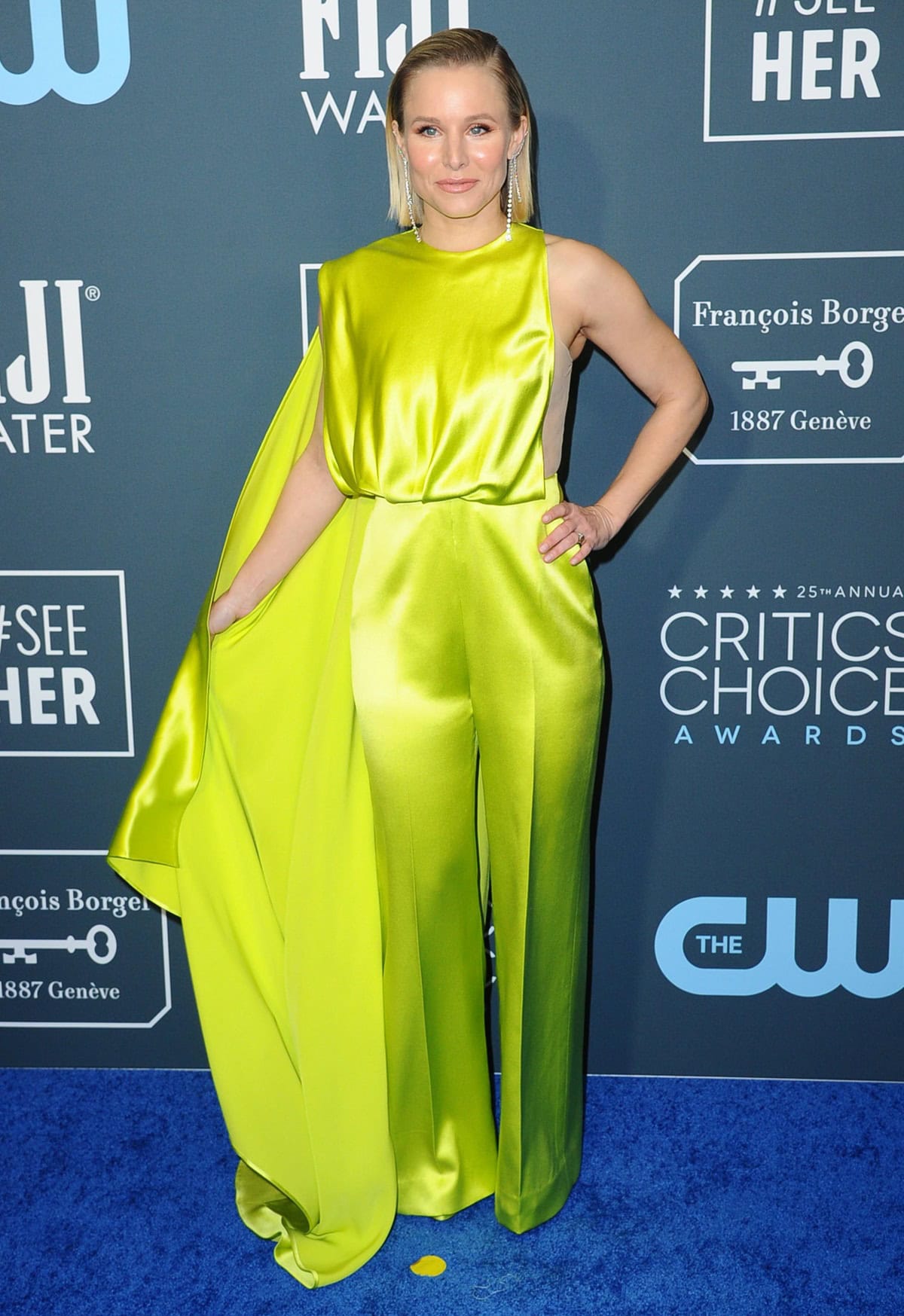 Kristen Bell wearing a Cong Tri jumpsuit, Forevermark jewelry, Christian Louboutin clutch, and Brian Atwood heels at the 2020 Critics’ Choice Awards