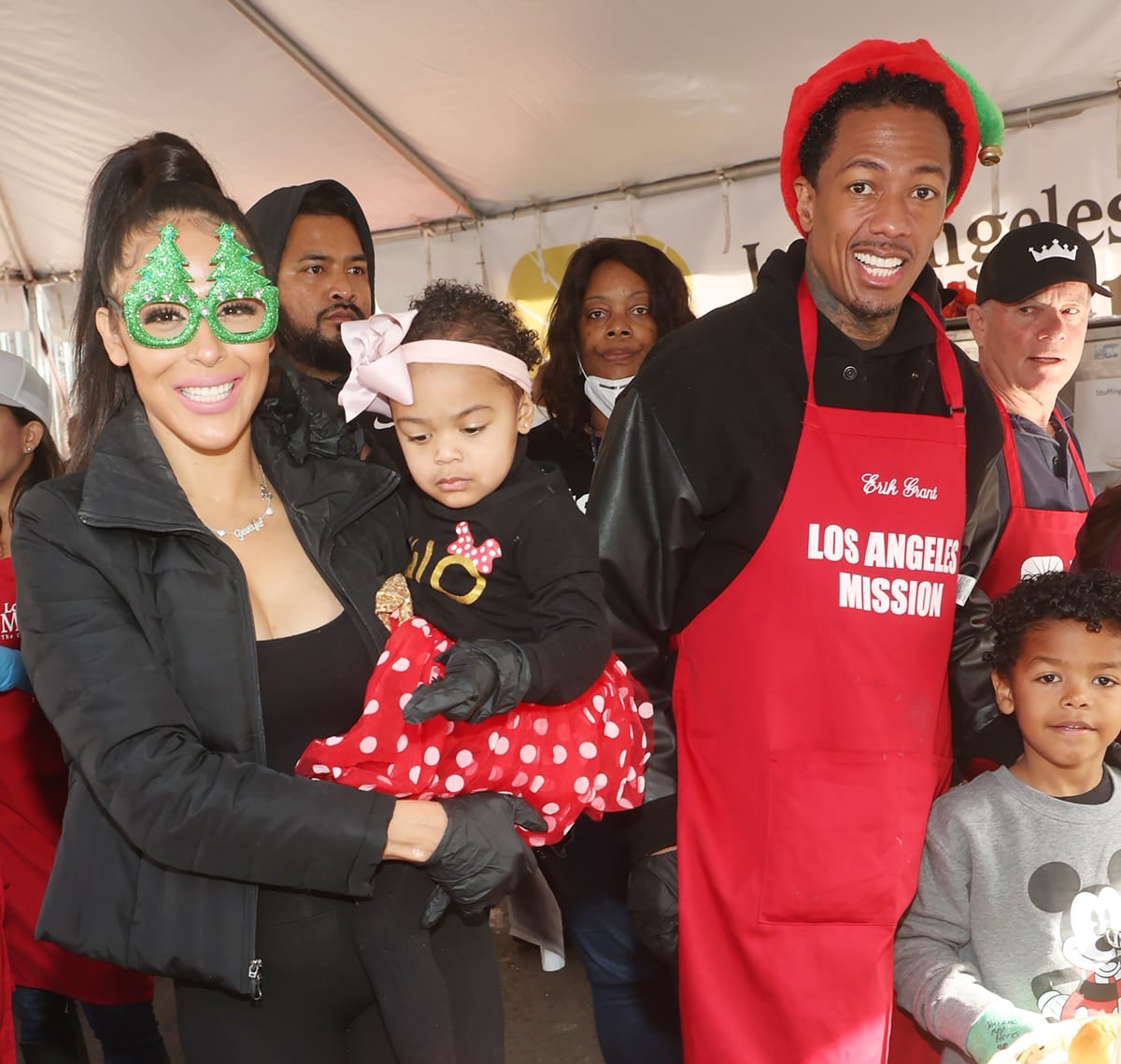 Nick Cannon, along with two of his children, Powerful Queen and Golden, and their mother, Brittany Bell, volunteered at the LA Mission's Annual Christmas Feed-The-Homeless Event