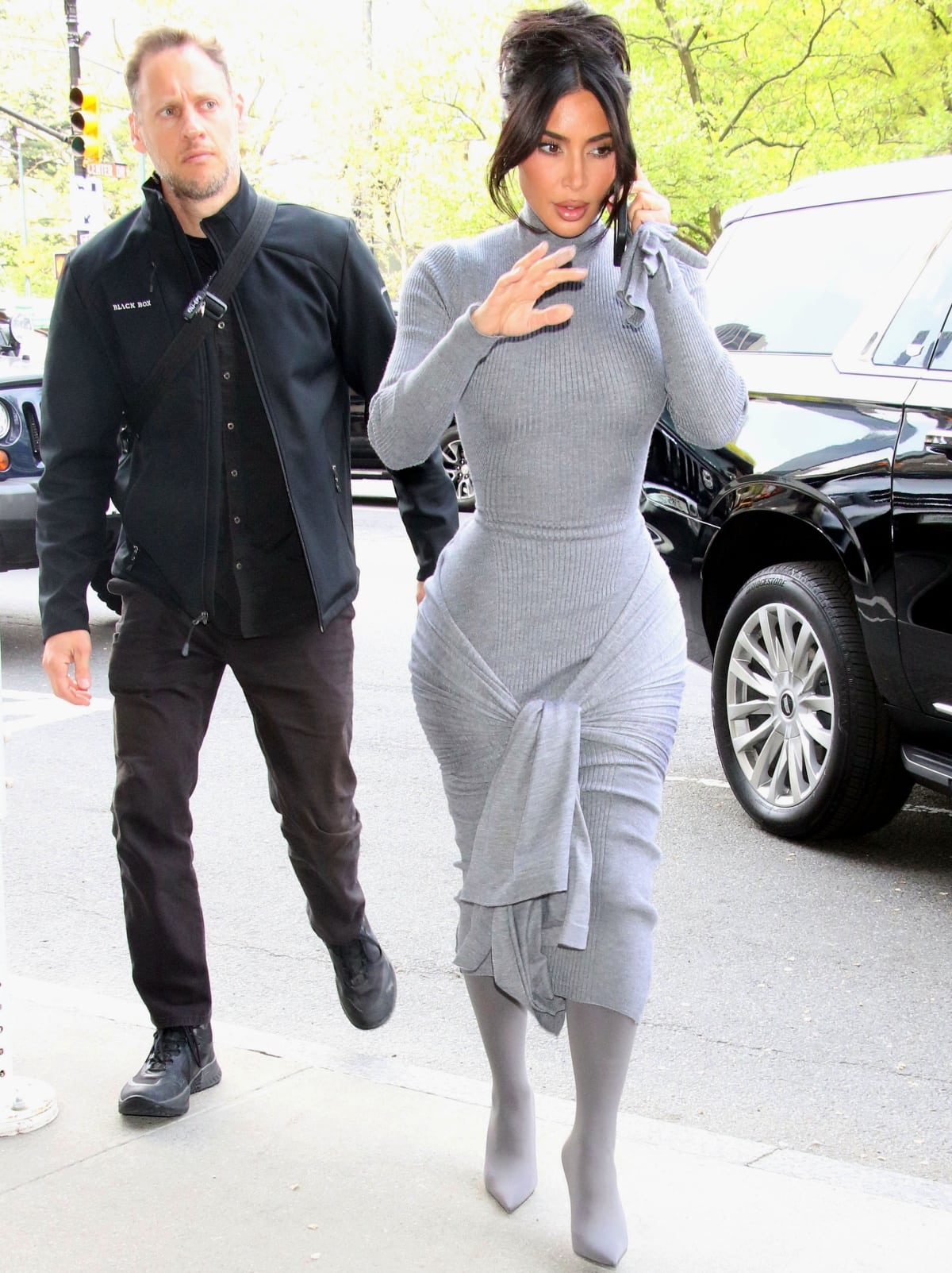Kim Kardashian wearing a grey Alaia silk and cashmere dress with a high neck, a ribbed design, and a wraparound tie detail at the bottom while out and about in New York City