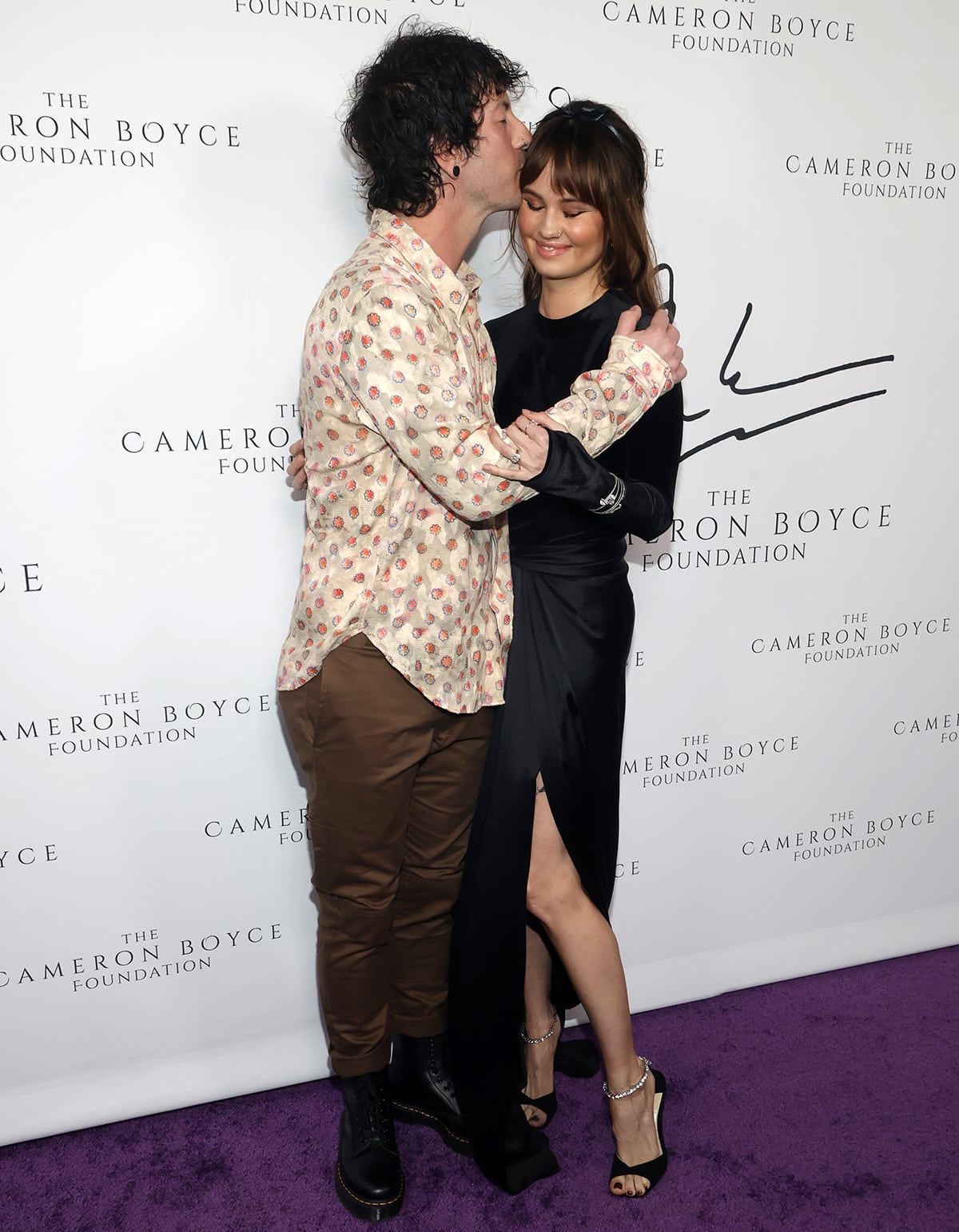 Josh Dun and Debby Ryan share a kiss on the purple carpet at the Cameron Boyce Foundation's 2nd Annual Cam For a Cause Gala at Citizen News Hollywood at The Thompson Hotel on June 1, 2023