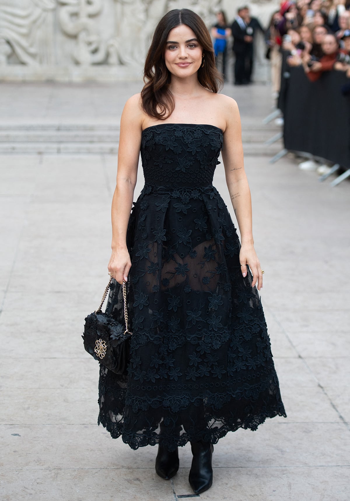 Lucy Hale opts for ladylike glamour in a black strapless dress with floral lace embroidery by Elie Saab at the Lebanese designer's Paris Fashion Week Womenswear Spring/Summer 2024 runway presentation on September 30, 2023