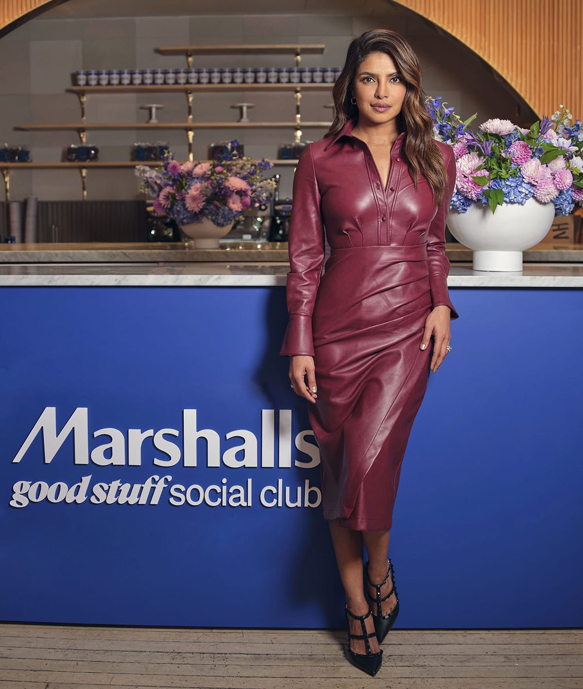 Priyanka Chopra's Jonathan Simkhai leather midi dress features a classic silhouette with long sleeves, a collar, and a draped skirt