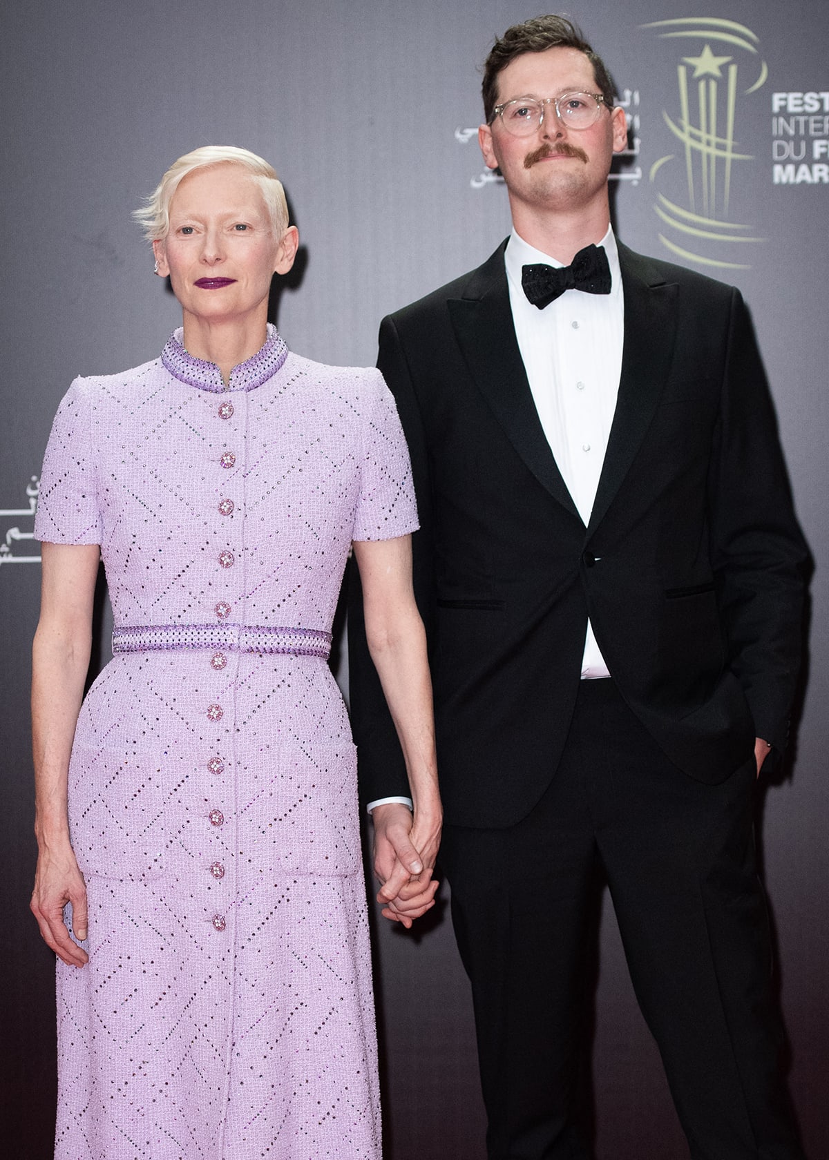 Tilda Swinton and son Xavier Swinton Byrne hold hands while posing on the red carpet at the 20th Marrakech International Film Festival held at Palais des Congrès in Marrakech, Morocco on November 24, 2023