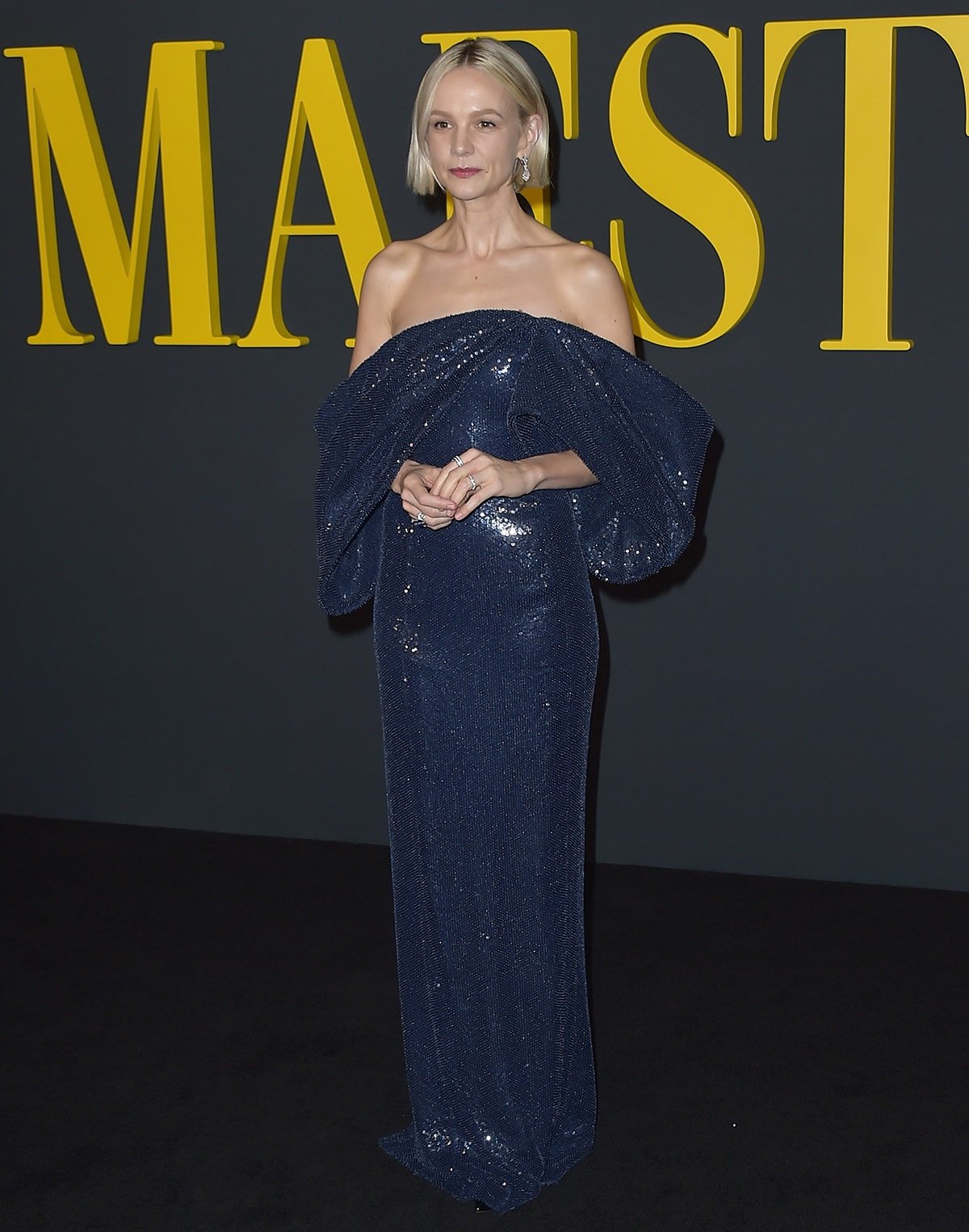 Carey Mulligan dazzles in a navy sequin-embellished gown with dramatic draped sleeves custom-designed by Celine for the Los Angeles premiere of Maestro on December 12, 2023