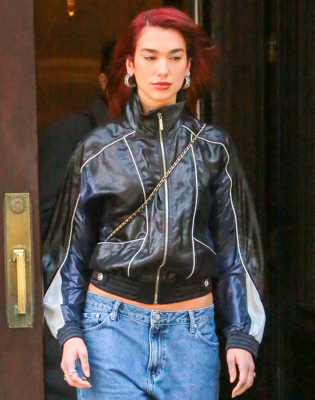 Dua Lipa radiates cool-girl energy as she styles her edgy jacket with chunky silver earrings and an array of rings