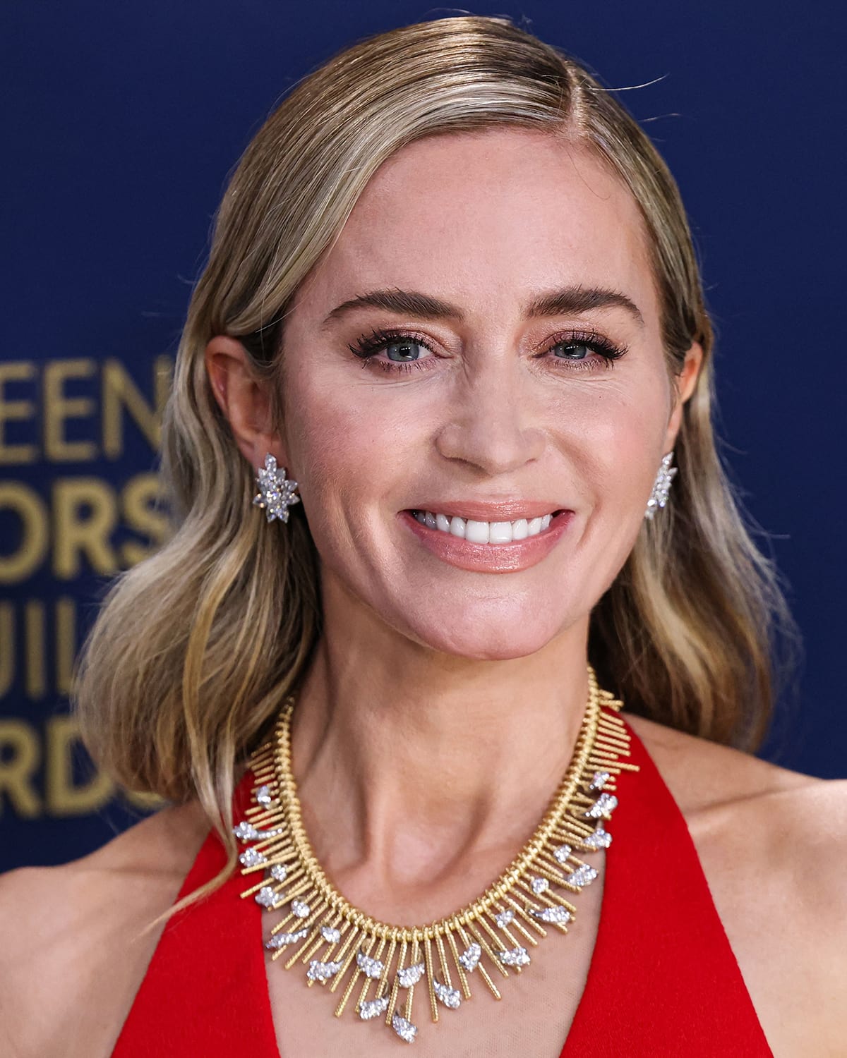 Emily Blunt keeps her glam understated, wearing soft pink makeup and Veronica Lake-esque wavy hairstyle