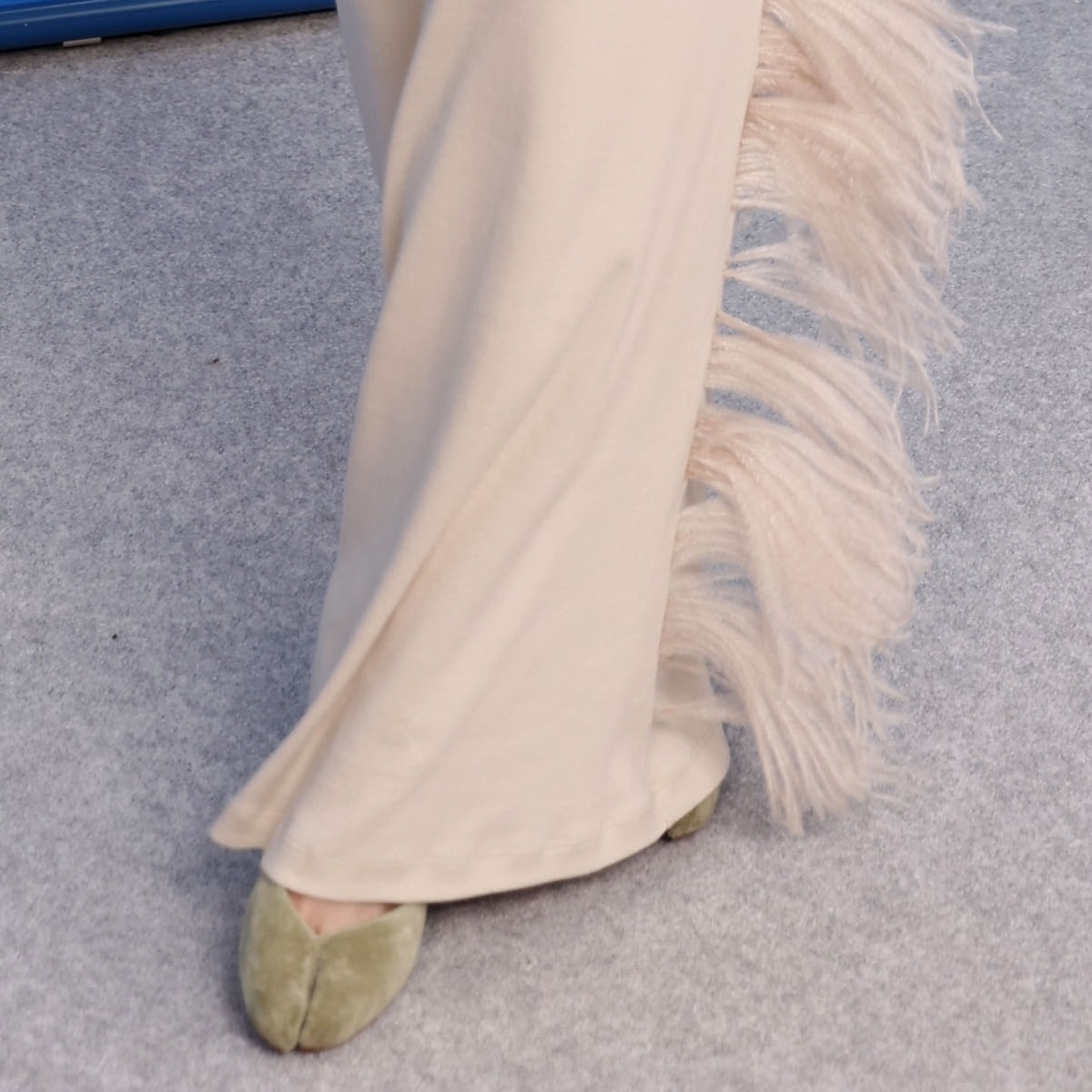 Hunter Schafer's look is perfectly complemented by moss-green suede Tabi ballet flats from Maison Margiela, marrying comfort with high fashion