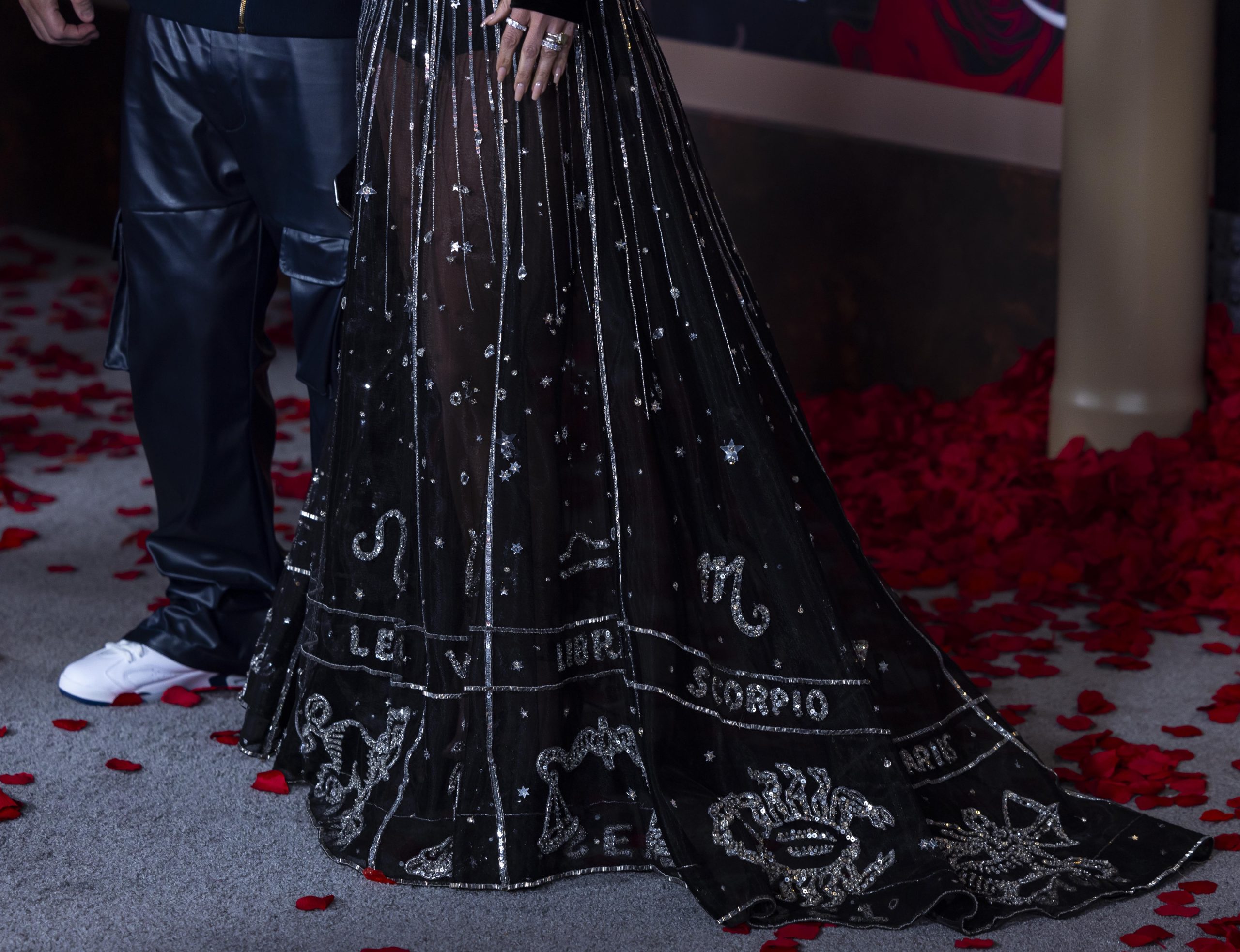 A closer look reveals the Leo zodiac emblem, a playful nod to Jennifer Lopez's astrological sign, embellishing her gown's hem, highlighting the star's connection to her celestial-themed project