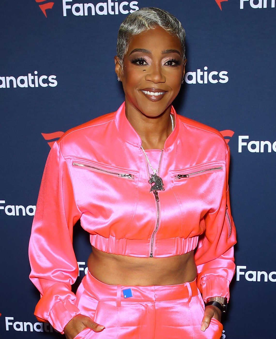 Tiffany Haddish styles her platinum hair in finger waves and wears complementary pink makeup to match her outfit