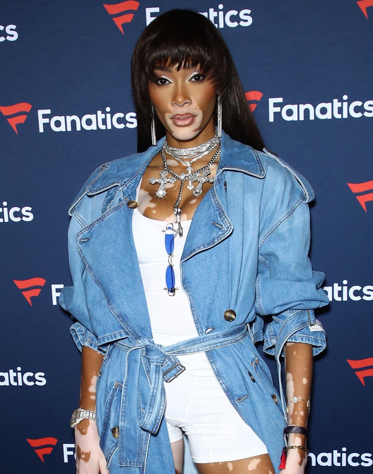 Maximalist fashionista Winnie Harlow styles her striking denim look with layers of diamond necklaces, earrings, and a diamond-encrusted watch