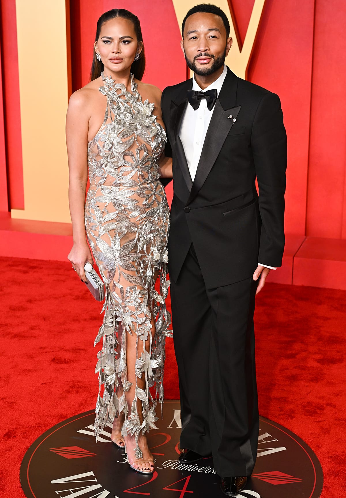 Chrissy Teigen and John Legend look great together in fashion-forward silver and black ensembles at the Vanity Fair Oscar Party 2024 on March 10, 2024