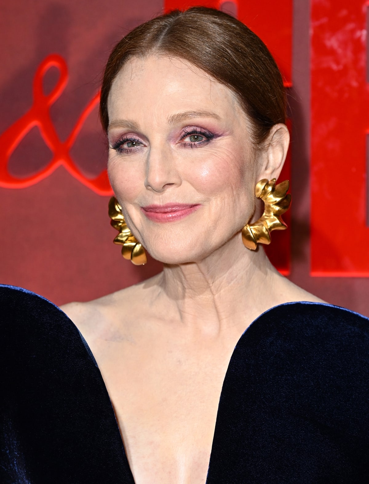 Opting for minimal accessories and understated elegance, Julianne Moore's Schiaparelli gown takes center stage, complemented by striking gold trompe l’œil croissant earrings