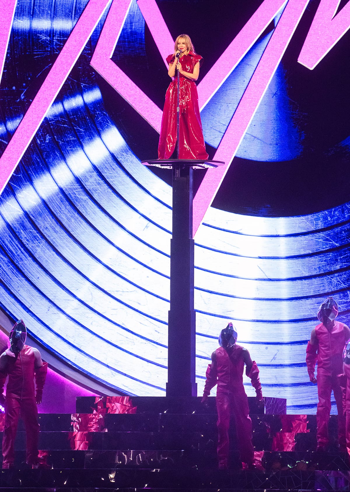 Kylie Minogue performs Padam Padam in a red latex trench coat by Dolce & Gabbana on the Brit Awards stage