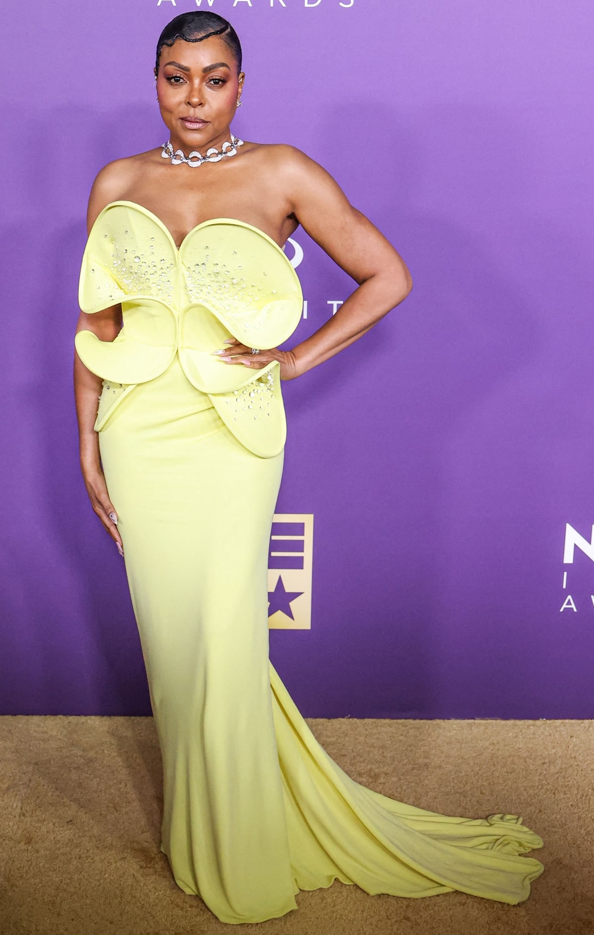 Taraji P. Henson radiates on the red carpet in a sculptural, strapless soft yellow dress with an oversized flower-like bodice, adorned with small crystals