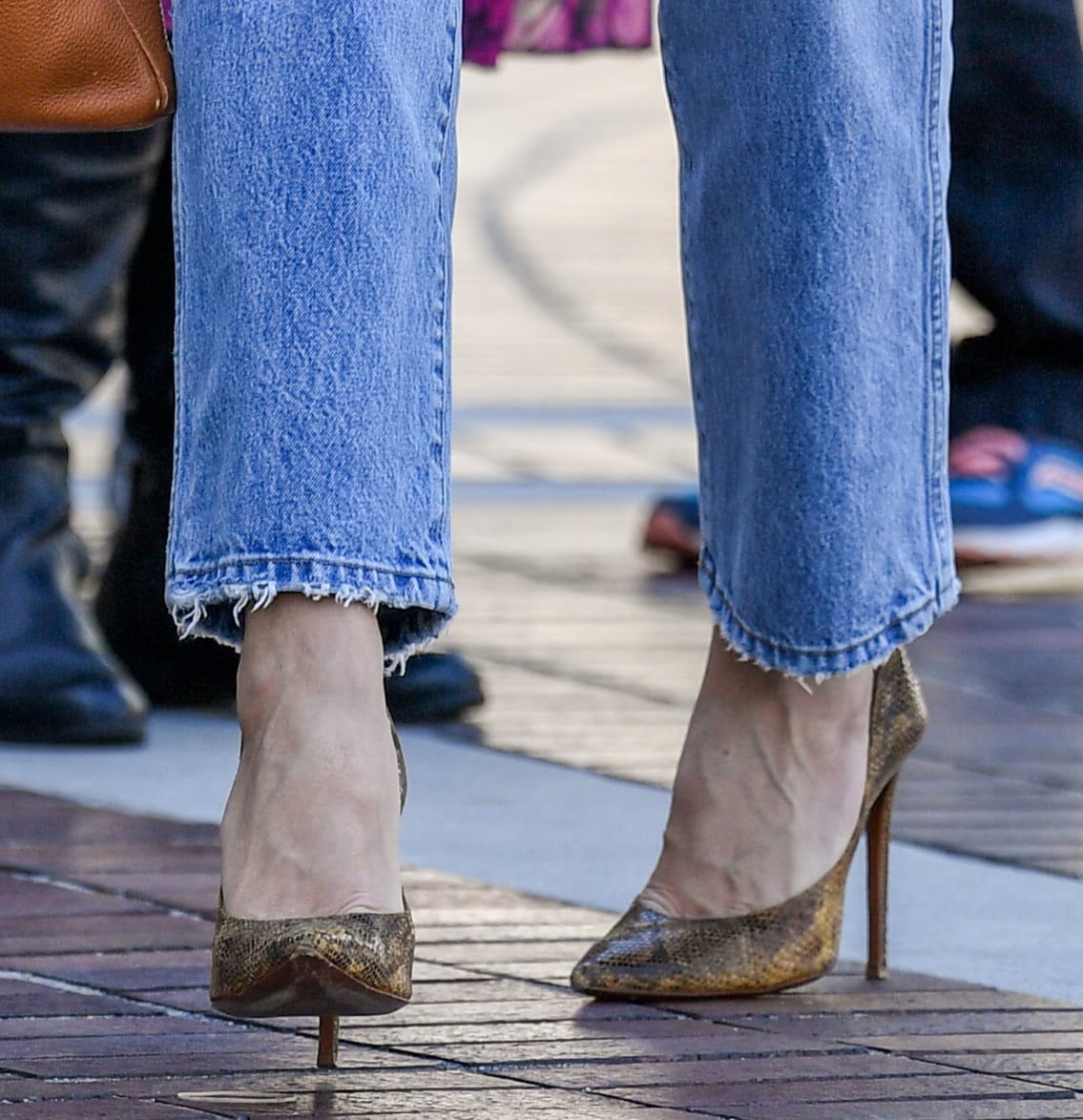 Heidi Klum pairs her pastel green top and blue denim jeans with brown accessories, including a pair of snakeskin pumps