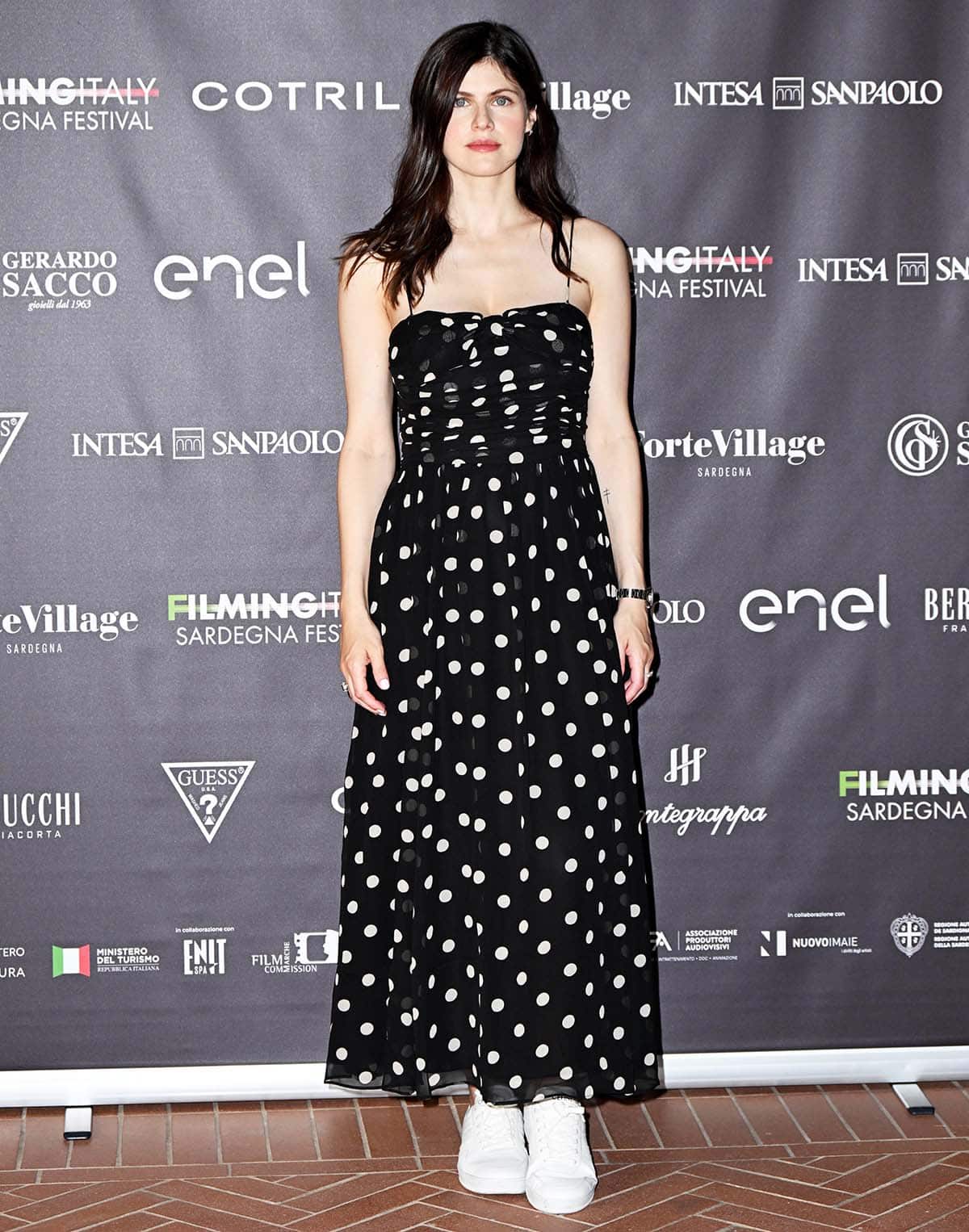 Alexandra Daddario styles her polka-dot dress with silver jewelry and maintains a carefree look by wearing her brunette hair in tousled waves