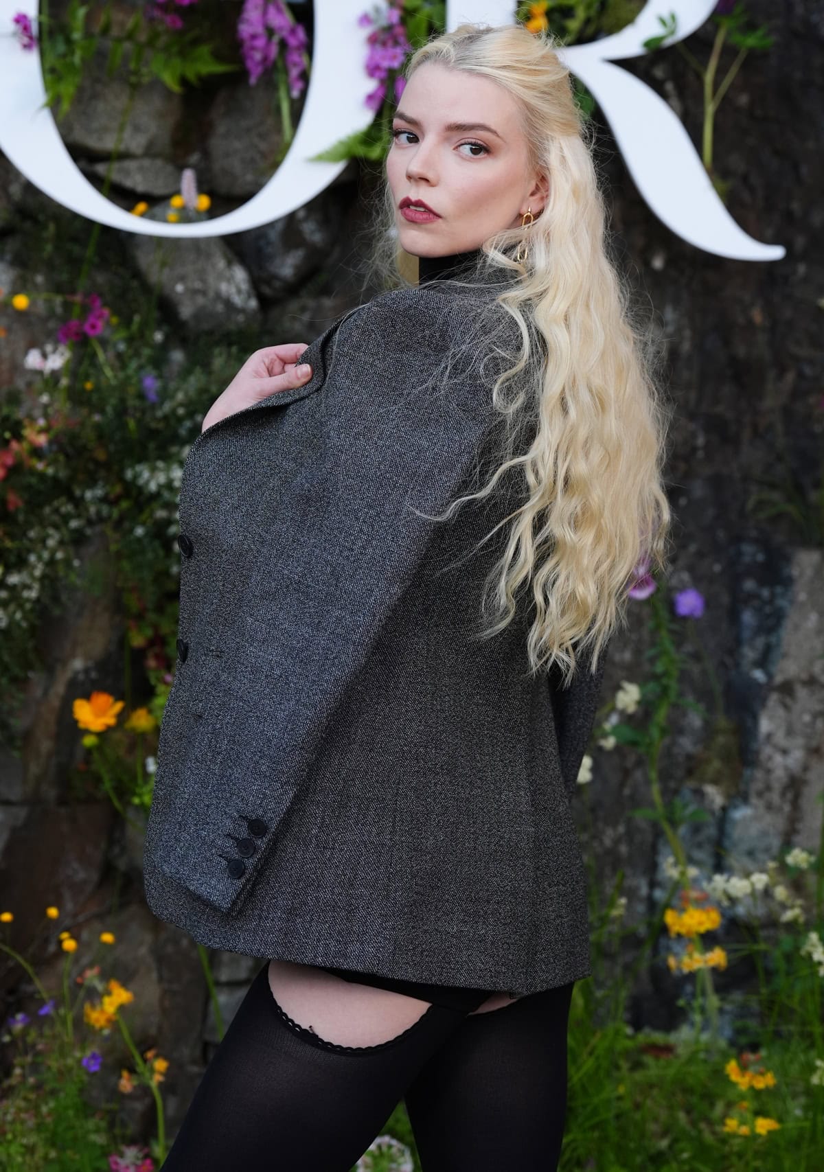 Anya Taylor-Joy's elegant look at the Dior Cruise 2025 show, featuring a gray blazer and black turtleneck