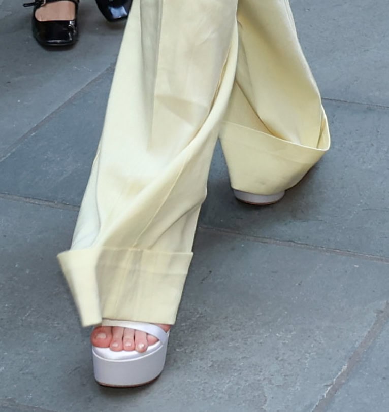 Dakota Danning pairs her yellow co-ords with white satin Stuart Weitzman Nudist Hollywood platform sandals