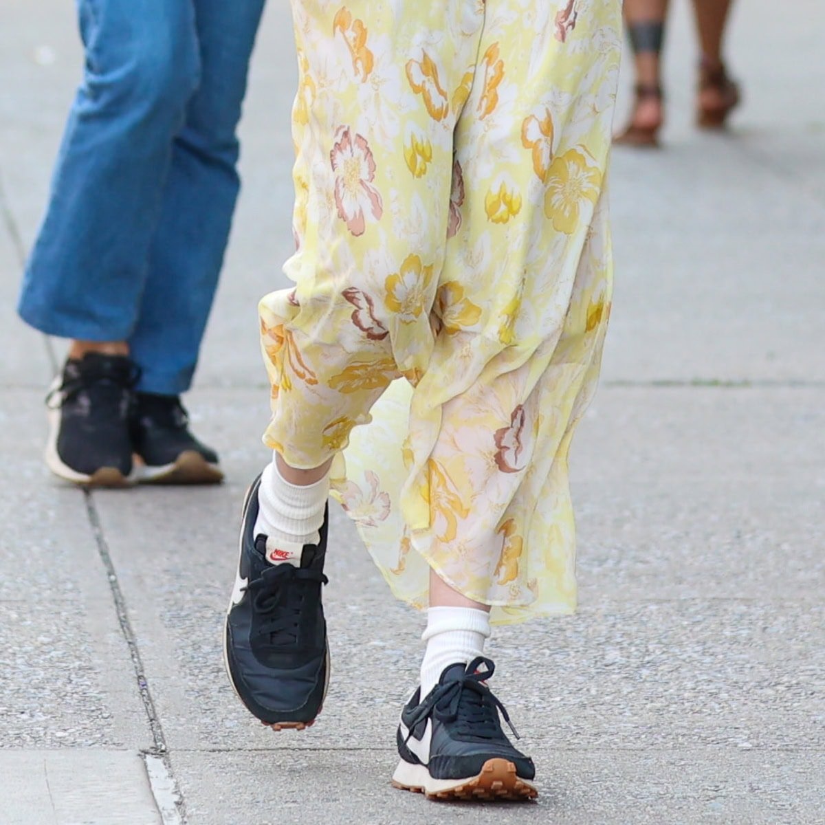 Dakota Johnson pairs her chic Doen Nevara sundress with classic Nike Daybreak sneakers, adding a casual edge to her look