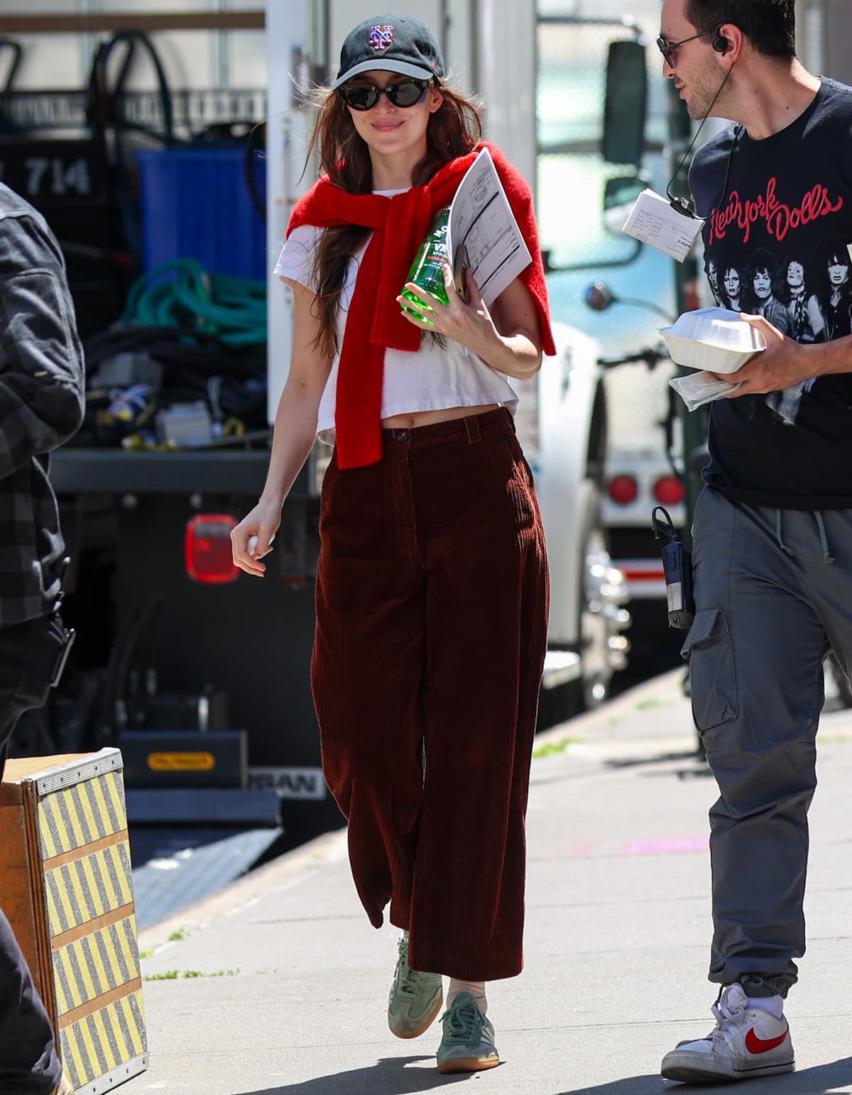 Dakota Johnson exudes effortless charm in a white cropped Re/Done tee and burgundy wide-leg trousers on the set of Materialists