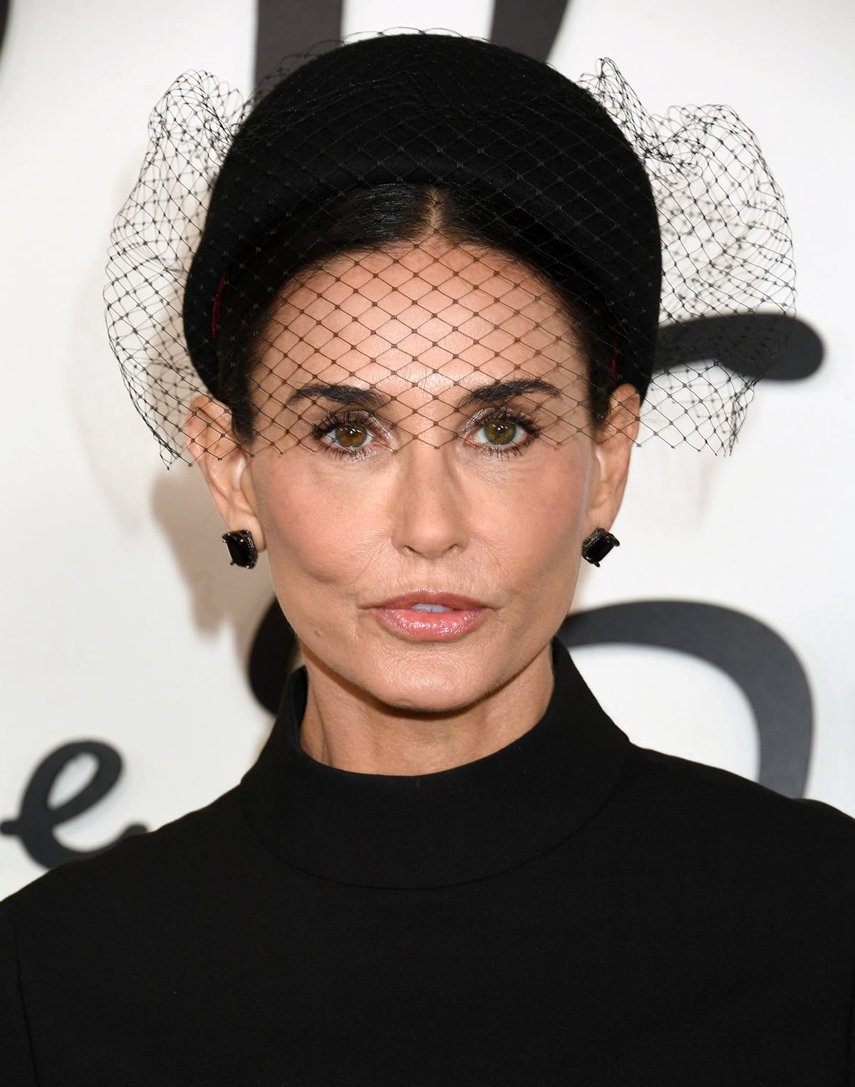 Demi Moore wears Anabela Chan’s Black Diamond Cushion Wing stud earrings and highlights her features with smudged eyeliner, smokey eyeshadow, and pink lips