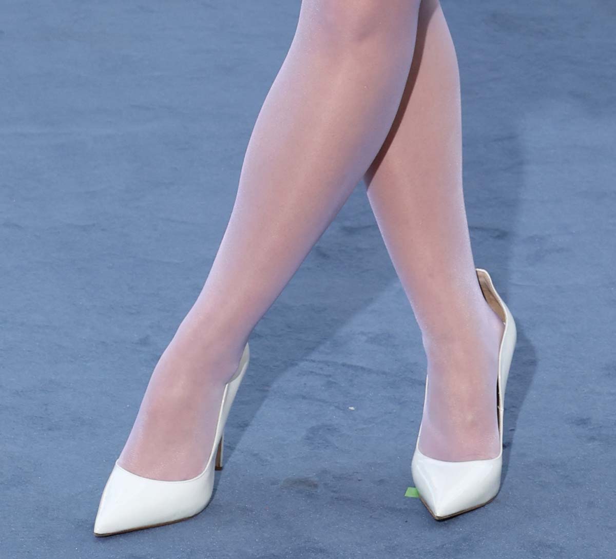 Joey King teams her futuristic white dress with white stockings and white patent Le Silla Ivy pumps