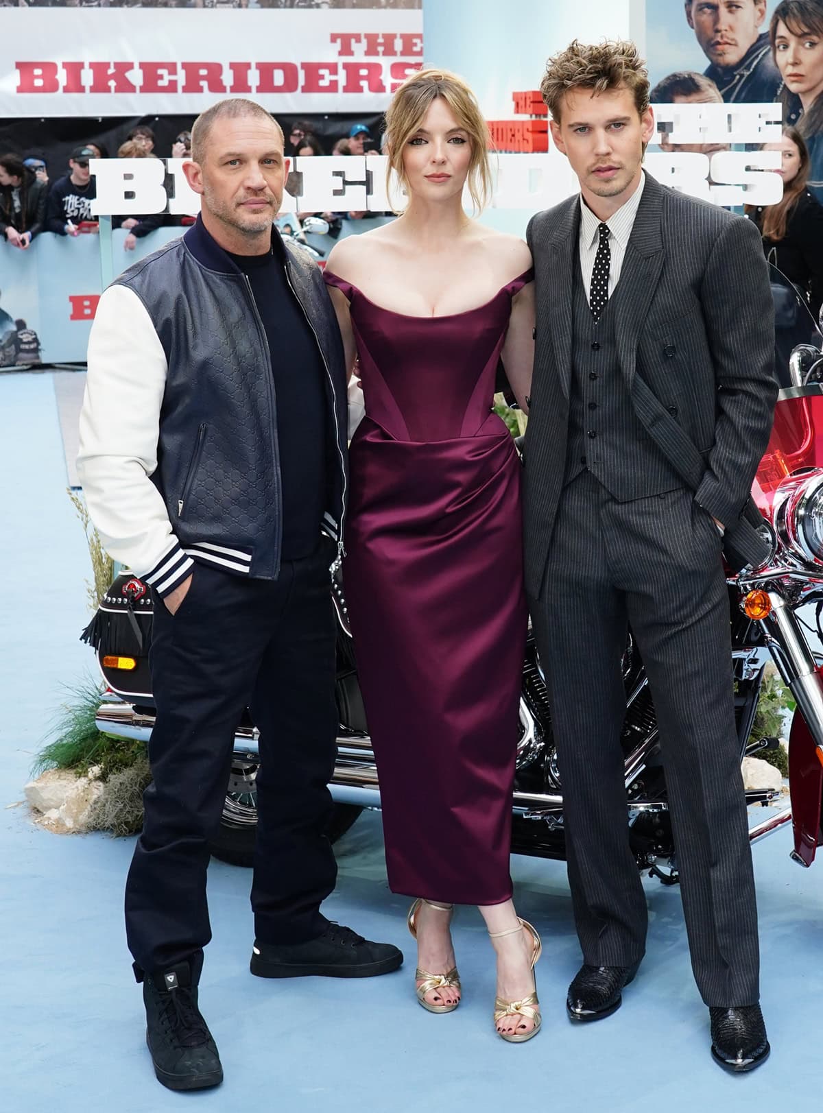 Tom Hardy, Jodie Comer, and Austin Butler pose together at the London premiere of 'The Bikeriders', showcasing their distinct styles on the red carpet